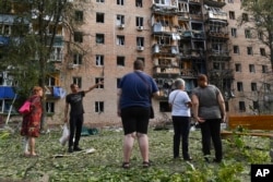 Шабуылдан қираған көпқабатты үйдің алдында тұрған адамдар. Курск, Ресей, 11 тамыз, 2024 жыл.