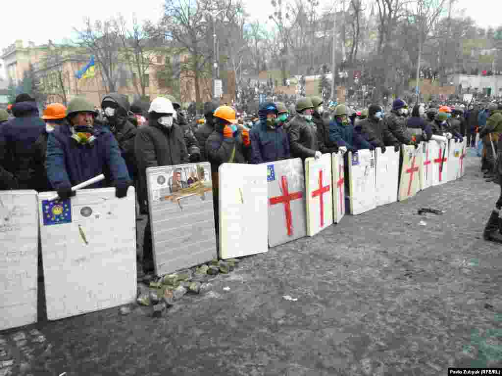 Деностранты в касках образовали линию обороны.