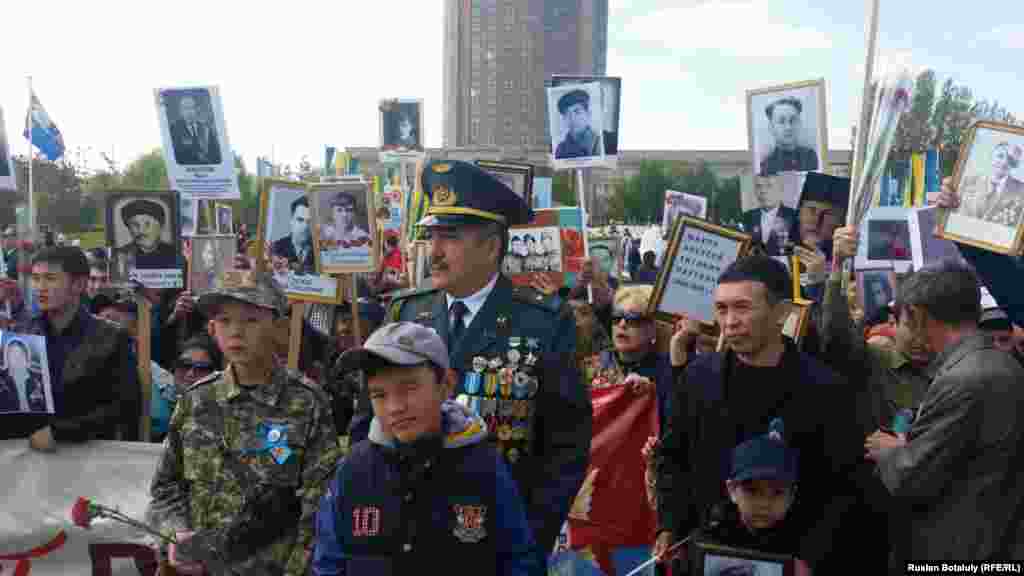 Астанада &laquo;Мәңгілік полк&raquo; шеруіне шыққандар екінші дүниежүзілік соғысқа қатысқан майдангерлер суреттерін ұстап тұр. 9 мамыр 2016 жыл.