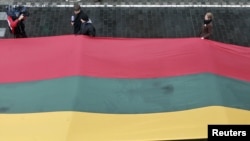 Lithuania -- People carry about 200 meter long sash in Lithuanian flag colours during Day of the Defenders of Freedom celebration in Vilnius, 13Jan2011