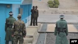 South Korea -- Korean soldiers stand guard at the tense border truce village of Panmunjom in the demilitarised zone, which splits the Korean peninsula, watched by North Korean soldiers with binoculars, 09Apr2013