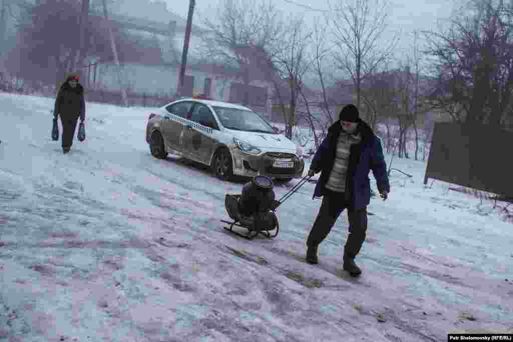 Житель Дебальцева везет емкость с питьевой водой, взятой из автоцистерны.