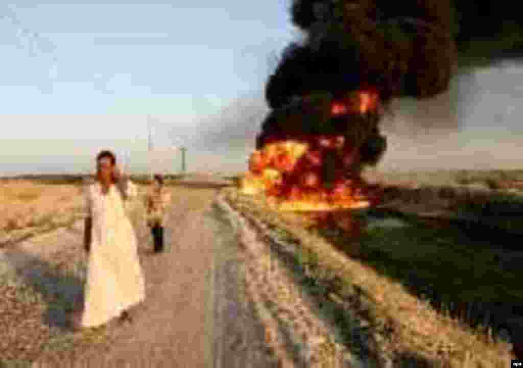 A sabotaged oil pipeline burns near Um Alubaid village, 40 km southeast of Baghdad on 27 August 2004. Insurgents have been targeting Iraq's oil infrastructure, causing large fluctuations in the global oil market. EPA