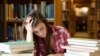 Generic -- (©Shutterstock) Student surrounded by books in a library