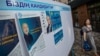 Kazakhstan – Early presidential election 2019. A woman walks past are election banners of Kazakh presidential candidates Kasym-Zhomart Tokaev and Amangeldi Taspikhov. Almaty, 14May2019